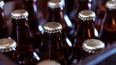 Flera glasflaskor med kapsylkork. Foto.