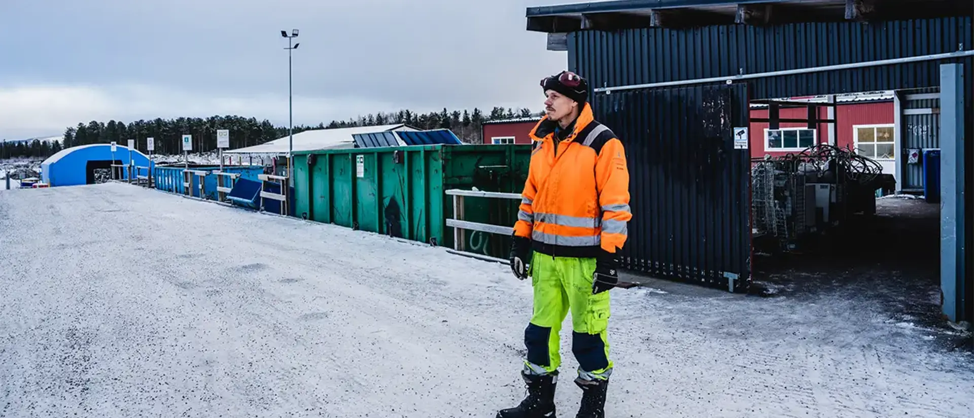 Återvinningscentralen i Jokkmokks avlämningsramp. En person ur personalen står i varselkläder redo att hjälpa till. Foto: CJ Utsi
