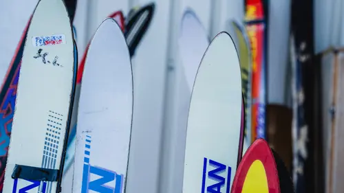 Äldre skidor uppställda på en ställning utomhus. Foto. 